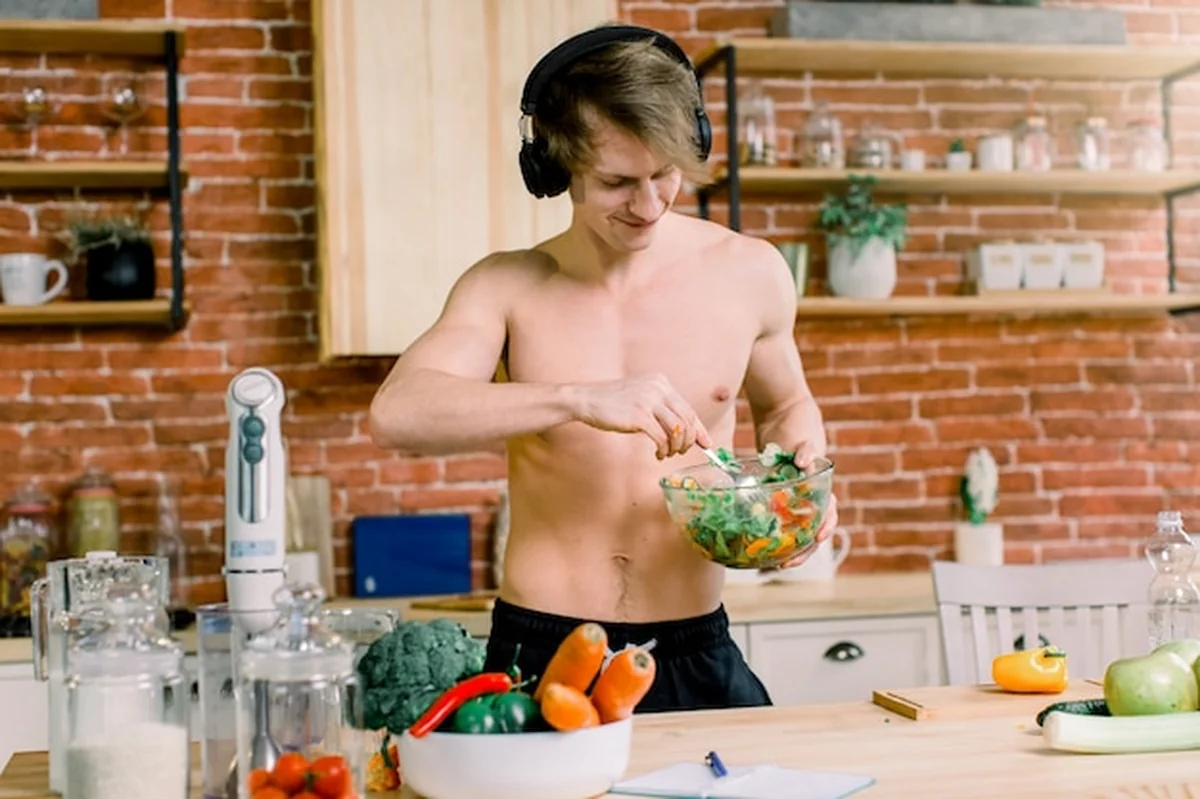 Mężczyzna tańczący w kuchni podczas przygotowywania sałatki