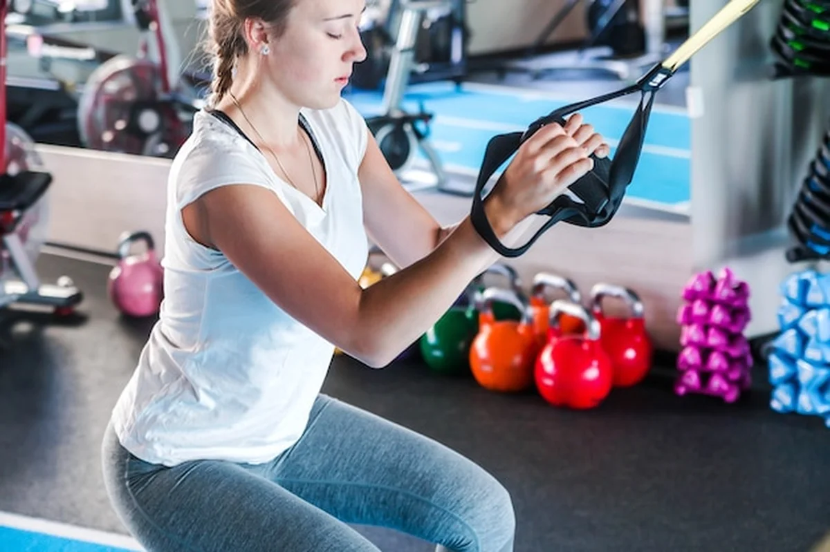 Trening na siłowni z dziewczynką fitness i trenerem fitness