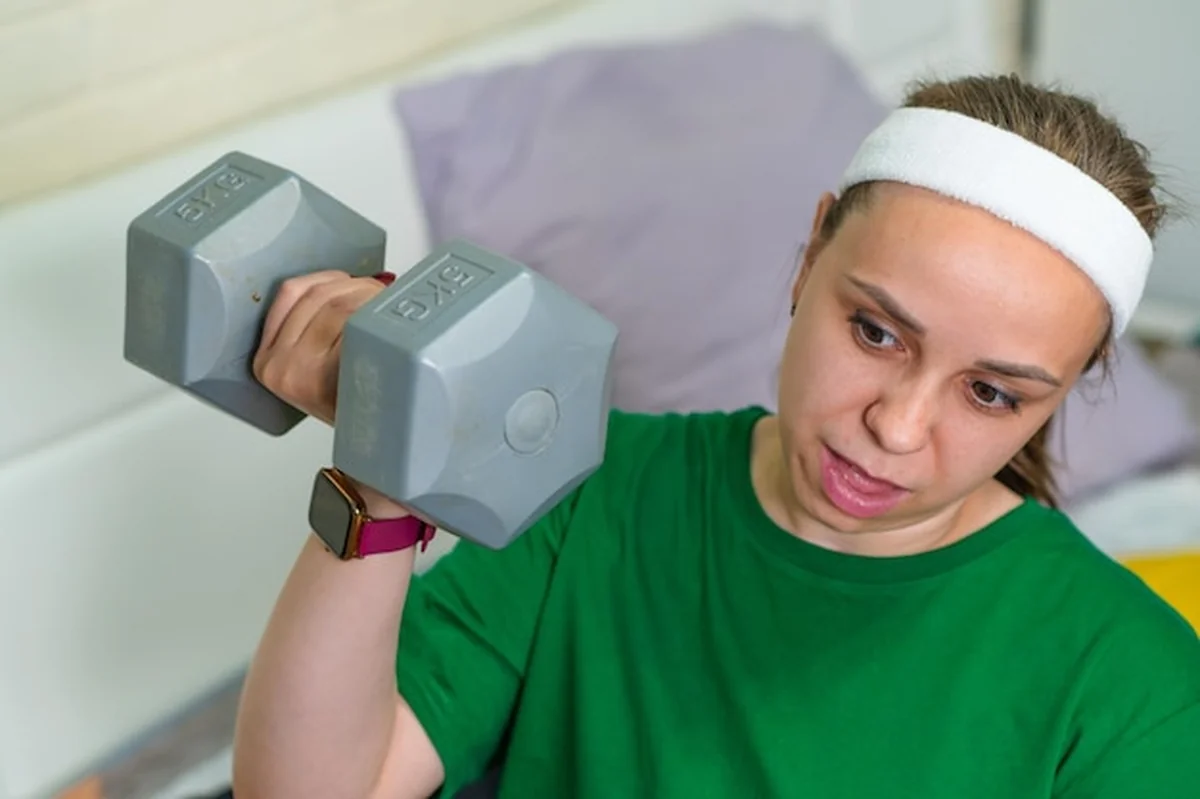 Młoda kobieta ćwiczy z halterem w studiu fitness