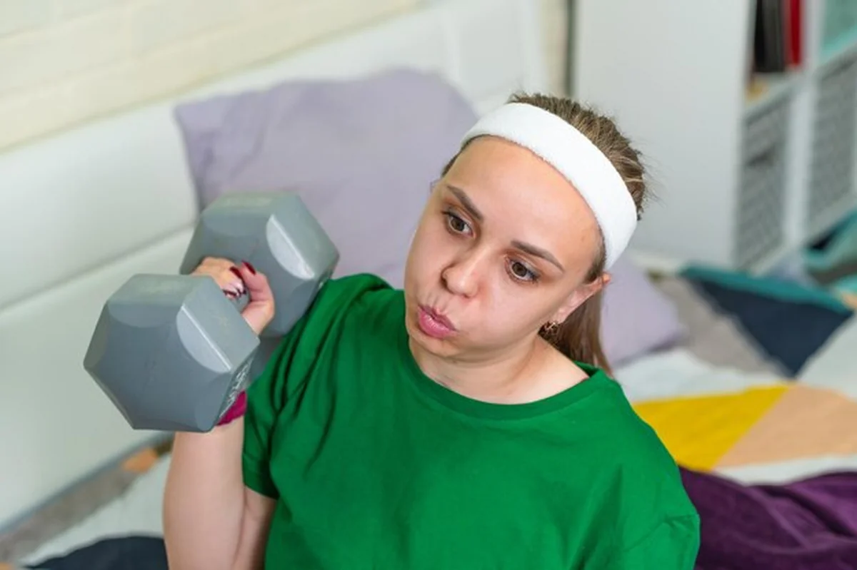 Młoda kobieta ćwiczy z halterem w studiu fitness